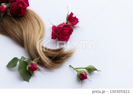 Hair with red roses flowers. Closeup. On a white background. Hair with red roses flowers. Closeup. On a white background. 130305822