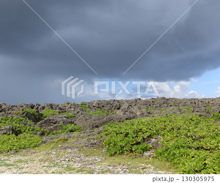 沖縄・残波岬の岩場に迫る雨雲　 130305975