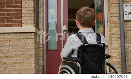 A first-grader in a wheelchair in front of the school entrance, symbolizing accessibility, inclusivity, and equal opportunities in education A first-grader in a wheelchair in front of the school entrance, symbolizing accessibility, inclusivity, and equal opportunities in education 130307058