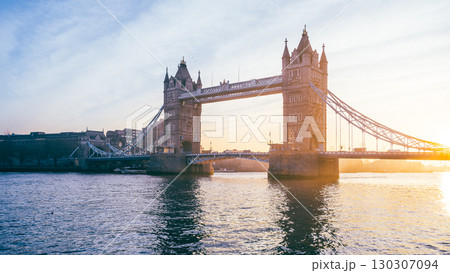 Tower Bridge stands majestically at sunrise, bathed in warm hues, with the River Thames reflecting the soft morning light in the heart of London, UK. Tower Bridge stands majestically at sunrise, bathed in warm hues, with the River Thames reflecting the soft morning light in the heart of London, UK. 130307094