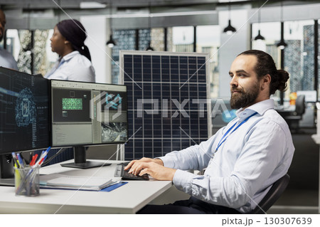 Engineer uses artificial intelligence to optimize sustainable solar panel fabrication with advanced assembly lines. Clean energy expert innovates solar manufacturing processes using AI deep learning 130307639