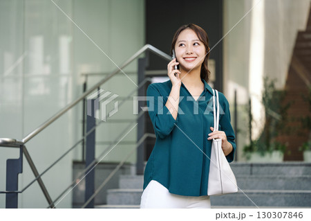 スマホで話す若いキャリアウーマン 130307846