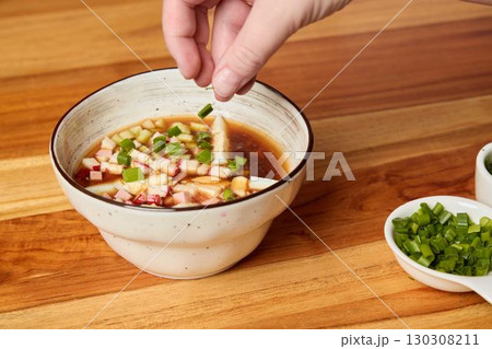 Enhancing a Flavorful Sauce Presentation by Garnishing with Fresh Green Onions for Appeal 130308211