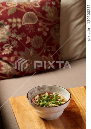 A Delicious Bowl of Soup Beautifully Arranged on an Elegant Wooden Table Setting A Delicious Bowl of Soup Beautifully Arranged on an Elegant Wooden Table Setting 130308235