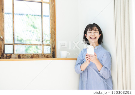 スマホを持つ女性 130308292