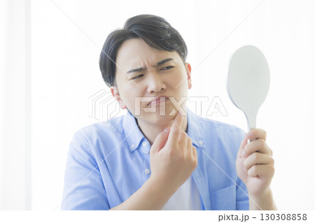 手鏡を見る男性 130308858