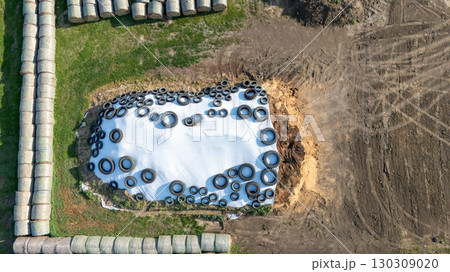 Farm storage practice utilizing tires for silage protection during summer months in a rural agricultural setting 130309020