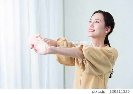 太陽光を浴びながらストレッチをする女性 太陽光を浴びながらストレッチをする女性 130311529