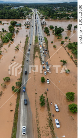 Aerial view of car driving on the road flooded after Kok river rising during heavy rain in Chiang Rai province, Thailand. 130312600