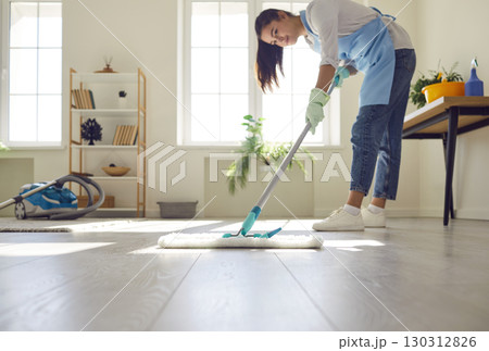 Housewife Mopping the Living Room Floor 130312826