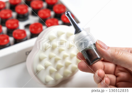 Closeup trichological ampoule applicator for hair restoration 130312835