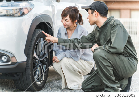 ロードサービスに駆けつけた作業員の男性とドライバーの女性 130313005