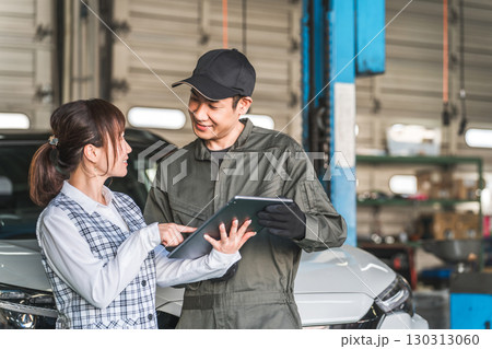 整備工場のピットでタブレットを見る従業員の男女（自動車整備工場・民間車検場・スタッフ） 130313060