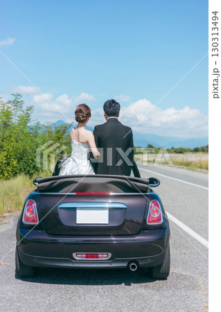 愛車とフォトウェディングを撮る新郎新婦（オープンカー） 130313494