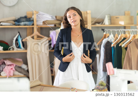 Woman trying on a jacket in the workshop 130313562