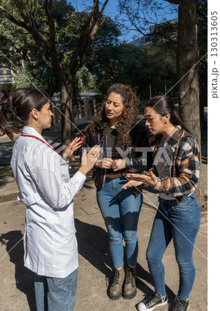 Doctor explaining diagnosis to worried patients outdoors 130313605