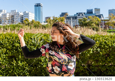 Young latin woman dancing outdoors in urban park setting Young latin woman dancing outdoors in urban park setting 130313620
