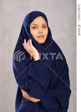 Portrait of young positive woman in khimara posing in studio 130313871