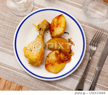 Barbecued chicken leg with boiled potatoes closeup on plate 130313888
