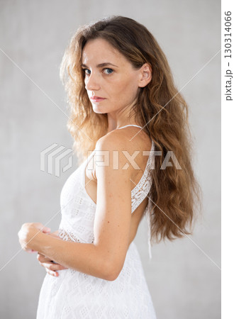 Portrait of middle aged woman smiling looking at camera over grey background 130314066