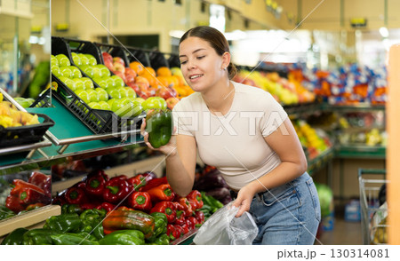 Young woman shopper chooses bell pepper in supermarket 130314081