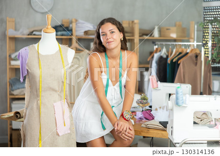 dressmaker playfully poses in the workshop 130314136