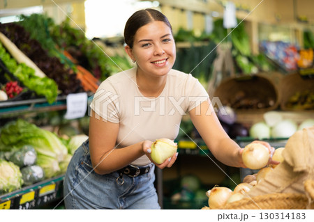 Portrait of female customer selecting onion in supermarket 130314183