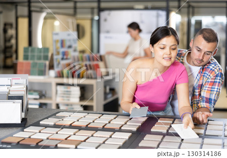 Couple man and woman choosing tile samples in store Couple man and woman choosing tile samples in store 130314186