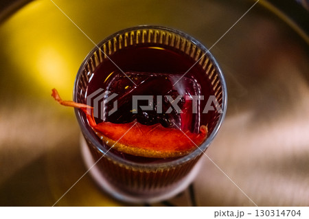 Negroni glass. Alcoholic drink. Red cocktail served with ice cube citrus slice peel. Aromatic refreshing liquor mix on pub counter. Negroni glass. Alcoholic drink. Red cocktail served with ice cube citrus slice peel. Aromatic refreshing liquor mix on pub counter. 130314704