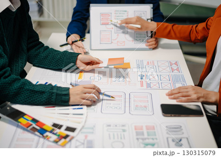 Close up view of UI developer team brainstorming on their project with laptop, smartphone and digital tablet. Close up view of UI developer team brainstorming on their project with laptop, smartphone and digital tablet. 130315079