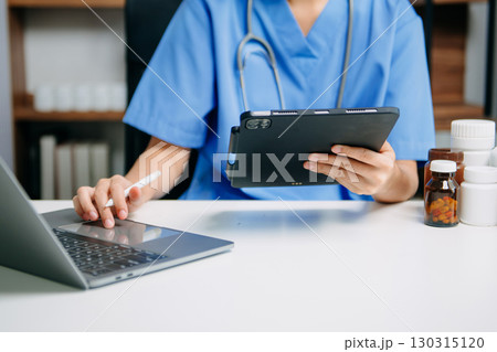 Medical technology concept. Doctor working with mobile phone and stethoscope and digital tablet laptop in modern office at hospital 130315120