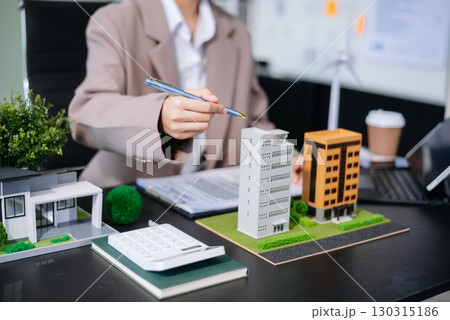 balancing the property sector The real estate agent is explaining the house style to see the house design and the purchase agreement. model house and comdo balancing the property sector The real estate agent is explaining the house style to see the house design and the purchase agreement. model house and comdo 130315186
