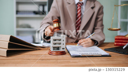 Real Estate Lawyer And House Foreclosure Law. House model, hammer judge gavel on table with white background. 130315229