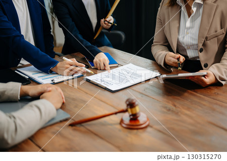 Business and lawyers discussing contract papers with brass scale on desk in office. Law, legal services, advice, justice and law Business and lawyers discussing contract papers with brass scale on desk in office. Law, legal services, advice, justice and law 130315270