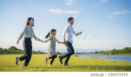 緑の丘で遊びまわる家族 130315330