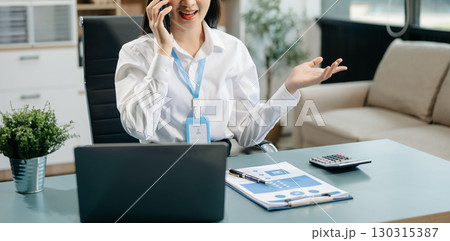 Confident business expert attractive smiling young woman typing laptop and holding digital tablet Confident business expert attractive smiling young woman typing laptop and holding digital tablet 130315387