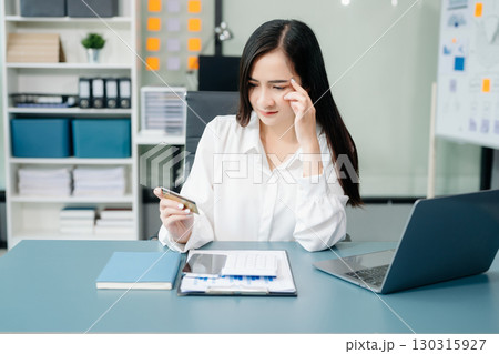 Financial owe, hand of asian woman sitting, holding credit card, stressed by calculate expense from invoice or bill, no money to pay, mortgage or loan. 130315927