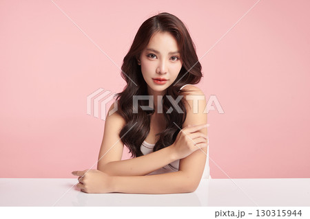 A beautiful young Asian woman with clean, fresh skin against a pink background. Skincare, facial treatment, cosmetology, beauty, and spa. An elegant portrait of an Asian woman. A beautiful young Asian woman with clean, fresh skin against a pink background. Skincare, facial treatment, cosmetology, beauty, and spa. An elegant portrait of an Asian woman. 130315944