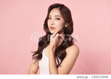 A beautiful young Asian woman with clean, fresh skin against a pink background. Skincare, facial treatment, cosmetology, beauty, and spa. An elegant portrait of an Asian woman. A beautiful young Asian woman with clean, fresh skin against a pink background. Skincare, facial treatment, cosmetology, beauty, and spa. An elegant portrait of an Asian woman. 130315946