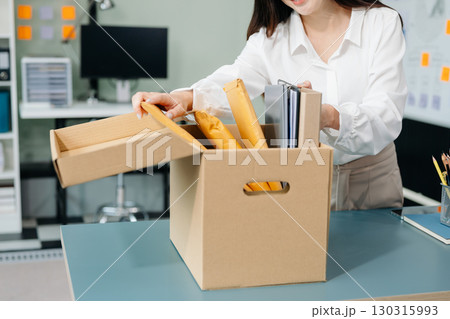 Happy and excited young beautiful Asian woman office worker celebrating her resignation, carrying her personal stuff. leaving job, changing or company. Happy and excited young beautiful Asian woman office worker celebrating her resignation, carrying her personal stuff. leaving job, changing or company. 130315993