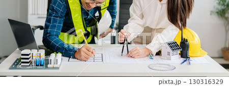 Two colleagues discussing data working and tablet, laptop with architectural project at construction site at desk Two colleagues discussing data working and tablet, laptop with architectural project at construction site at desk 130316329
