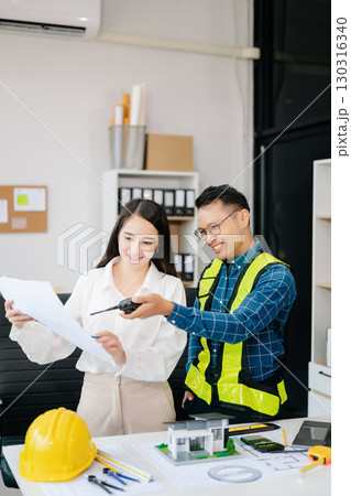 Engineer Teamwork Meeting, Drawing working on blueprint meeting for project working with partner on model building at company office Engineer Teamwork Meeting, Drawing working on blueprint meeting for project working with partner on model building at company office 130316340