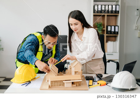 Engineer Teamwork Meeting, Drawing working on blueprint meeting for project working with partner on model building at company office Engineer Teamwork Meeting, Drawing working on blueprint meeting for project working with partner on model building at company office 130316347