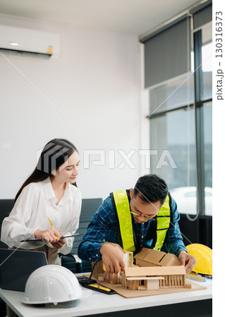 Engineer Teamwork Meeting, Drawing working on blueprint meeting for project working with partner on model building at company office 130316373