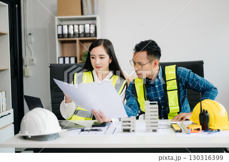 Creative architect projecting on the big drawings with architectural project at construction site at desk Creative architect projecting on the big drawings with architectural project at construction site at desk 130316399