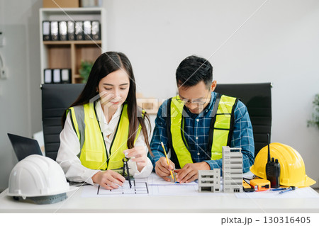Creative architect projecting on the big drawings with architectural project at construction site at desk Creative architect projecting on the big drawings with architectural project at construction site at desk 130316405