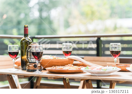 ウッドデッキのテーブルに並んだホームパーティー・グランピングの洋食,料理,ワイン ウッドデッキのテーブルに並んだホームパーティー・グランピングの洋食,料理,ワイン 130317211