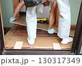 大工さんがローカに板を張り付けている 130317349