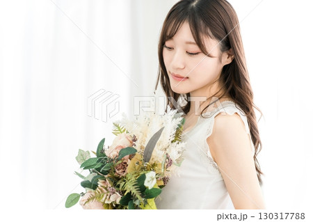 ドライフラワーのスワッグを持つおしゃれな女性 130317788