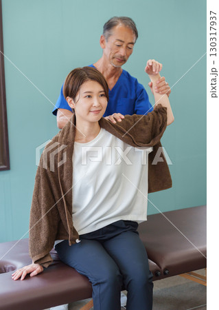 施術する整骨院の先生と患者 施術する整骨院の先生と患者 130317937